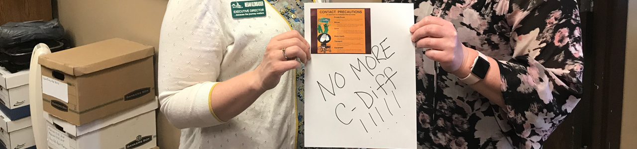Two health professional staff holding a "No more Cdiff" sign