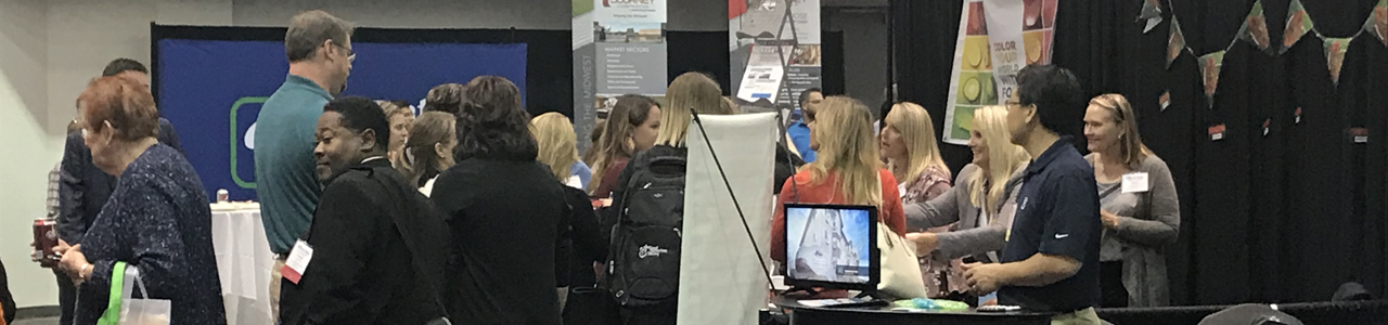 Great Plains Quality Innovation Network staff answering questions at the South Dakota Association of Healthcare Organizations vendor booth. 